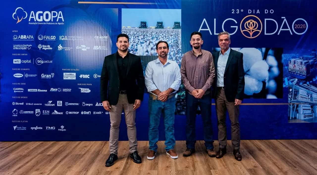 Quatro participantes posam diante do painel do 23º Dia do Algodão