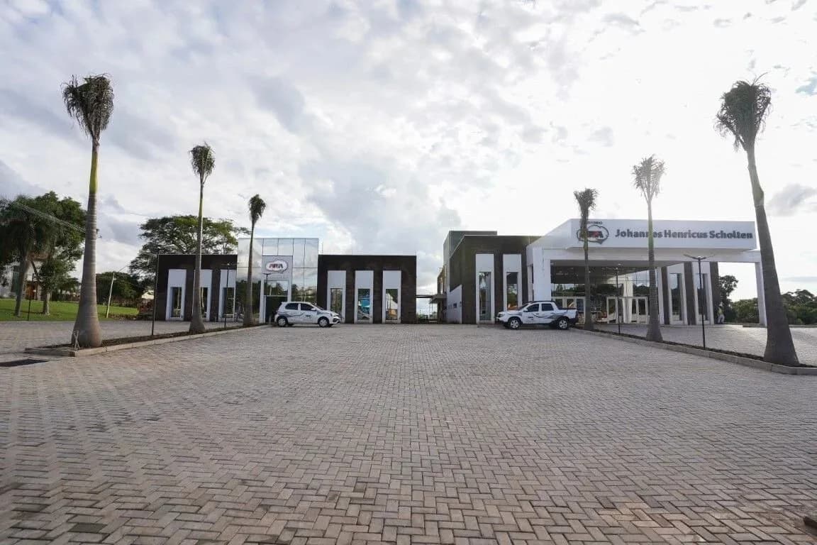 Vista externa do conjunto, com as palmeiras e o estacionamento
