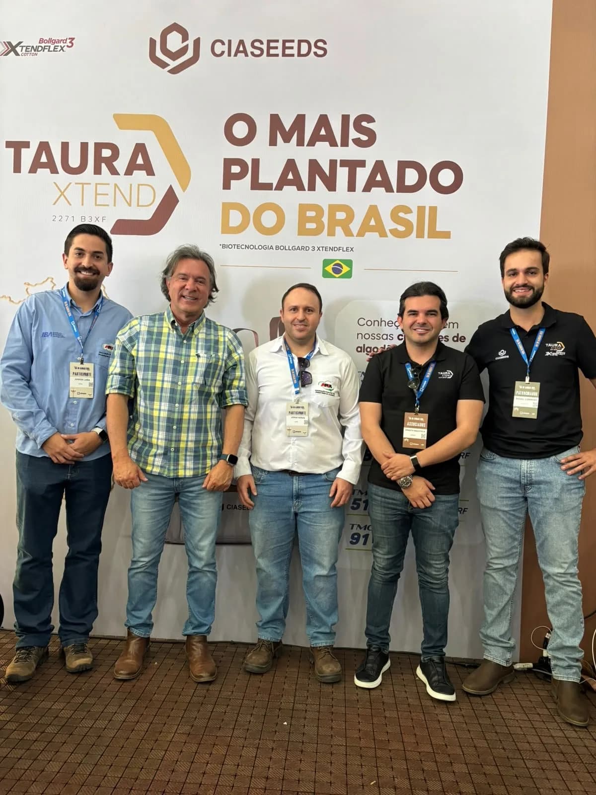 Participantes diante do painel de um patrocinador, durante o Dia do Algodão