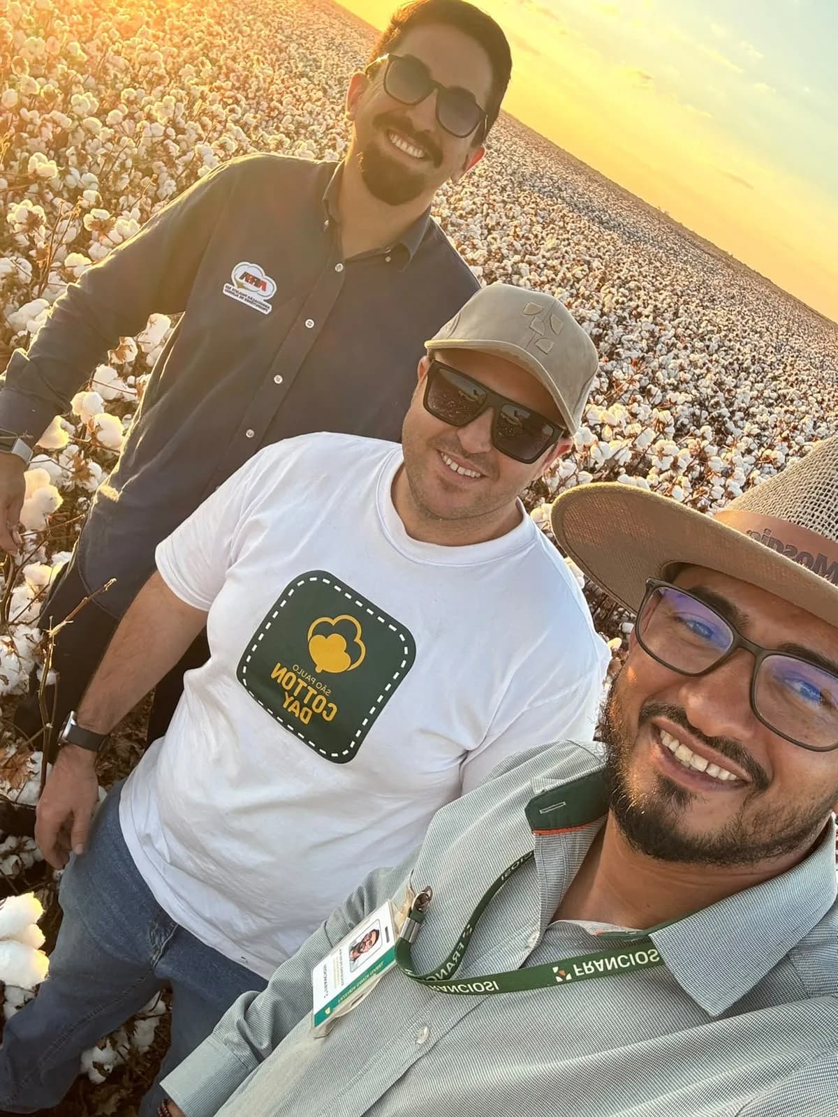 Três participantes posam no algodoal, no fim da tarde