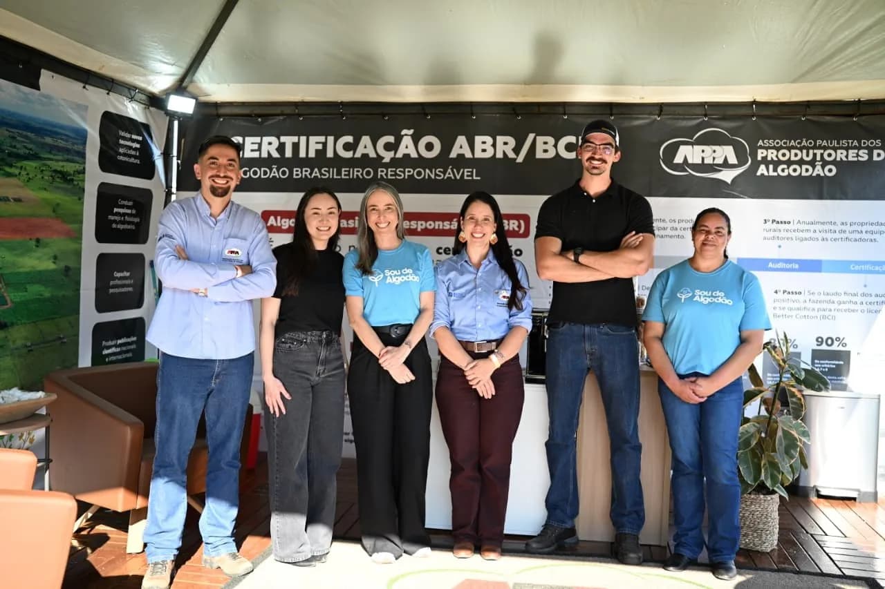Equipe da APPA no estande, com o painel de certificação ao fundo