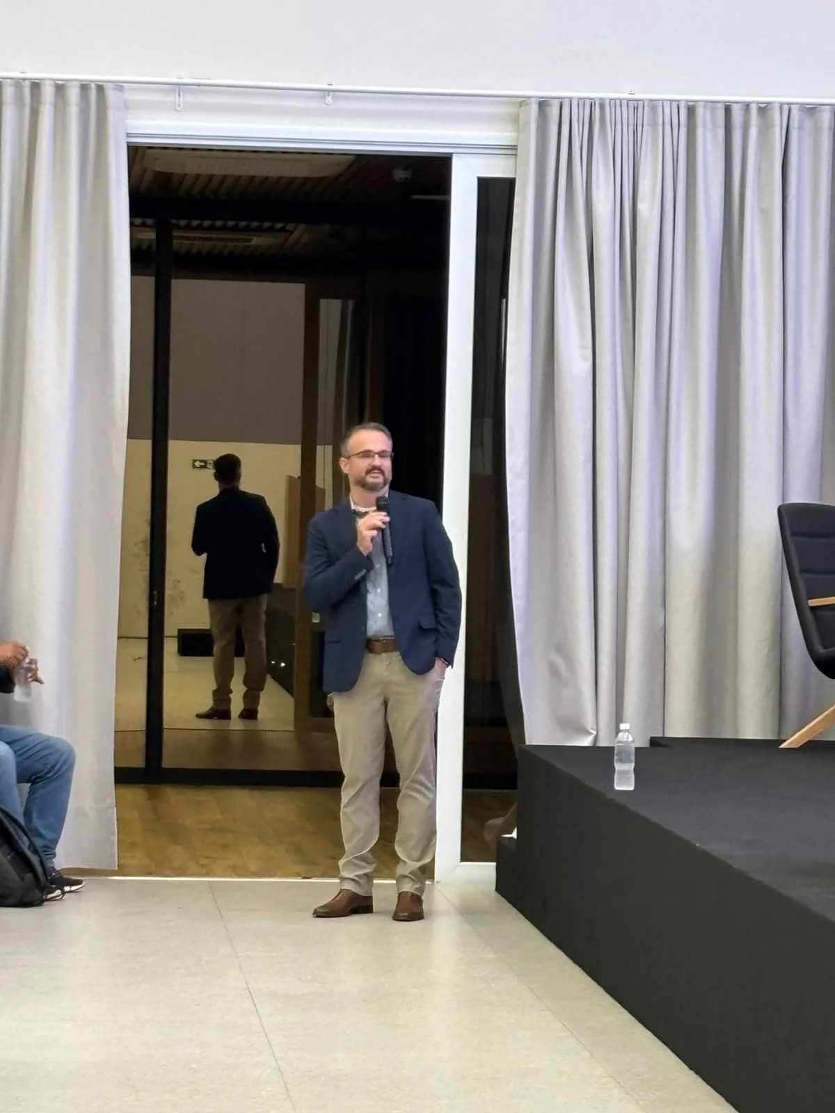 Palestrante em pé no auditório, durante a apresentação